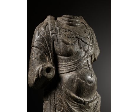 A LIMESTONE TORSO OF A BODHISATTVA, TANG DYNASTYChina, early 8th century. The slender, elegant figure well carved standing in