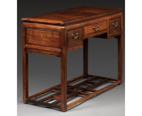 A HUANGHUALI THREE-DRAWER DESK, 19TH CENTURYChina. The top is set in a rectangular frame above three drawers, each with metal