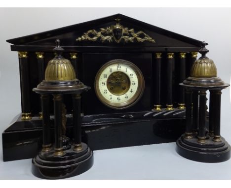 A BLACK MARBLE ARCHITECTURAL MANTEL CLOCK GARNITURE, having circular enamelled dial with Arabic numerals, four pillars either