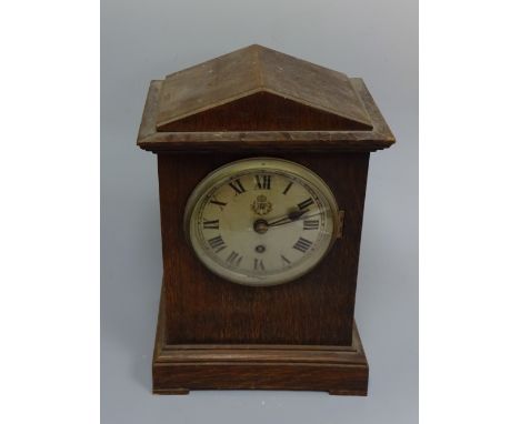 AN OAK CASED RAF MANTEL CLOCK, having silvered circular dial with Arabic numeral chapter ring inscribed RAF with Crown over, 