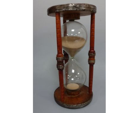 A TREEN EGG TIMER, having turned supports and banded wheels to top and bottom and mid pillars, approximately 17cm diameter x 