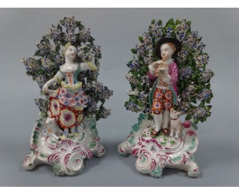 A PAIR OF 18TH CENTURY DERBY FIGURAL CANDLESTICKS, c.1780,  modelled as boy playing pipe with dog at feet before floral bocag