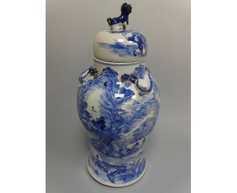 AN ORIENTAL BLUE AND WHITE BALUSTER VASE AND COVER, decorated with figures in landscape scenes, relief moulded dragons to top