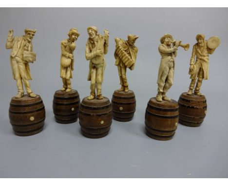 A SET OF SIX 19TH CENTURY FRENCH IVORY FIGURES, modelled as musicians playing instruments stood atop walnut ebonised bound ba