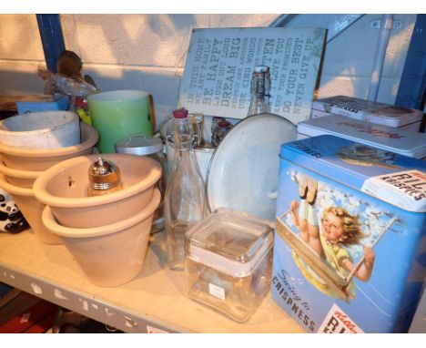 Shelf of mixed items advertising tins terracotta planters etc