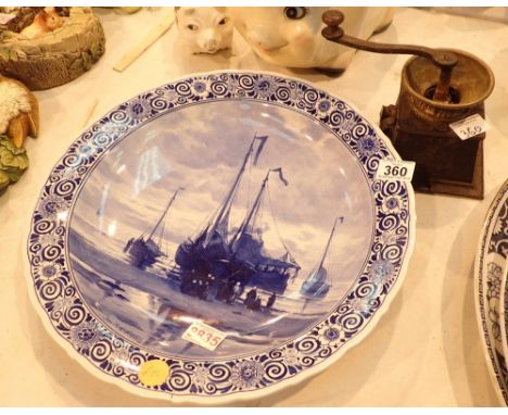 Large blue Delft charger with a shipping scene to the front and a vintage coffee grinder 