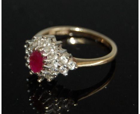 A 9ct gold, ruby and moissanite cluster ring, arranged as a centre oval cut ruby in a surround of small brilliants, 3.4g, siz