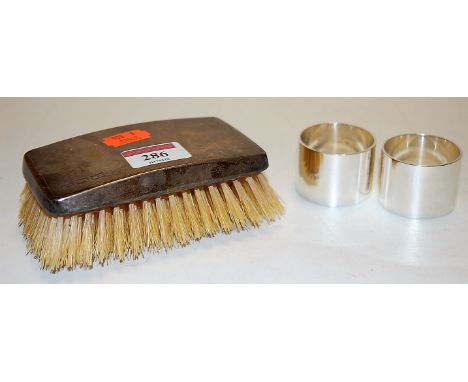 A George V silver backed hand brush, having all over engine turned decoration together with a pair of modern silver napkin ri