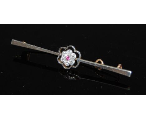 A 15ct gold and platinum faced bar brooch, centre set with a flower containing ruby within a surround of six old cut small di
