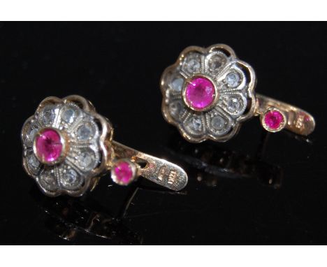 A pair of antique yellow metal, ruby and diamond set ear clips, each having centre illusion set round cut ruby in a surround 
