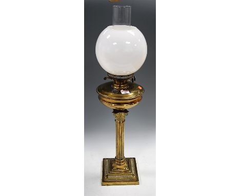 An early 20th century brass oil lamp, having opalescent globular shade above a brass reservoir, on fluted column with Corinth