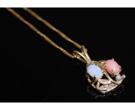 A modern 14ct gold pendant set with a cabochon coral opal and a single small brilliant cut diamond, 2.7cm, on finelink neck c