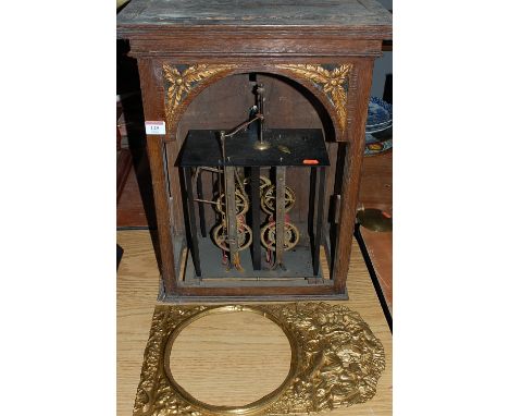 A 19th century French comtoise clock movement; together with a pressed brass surround depicting a farmhand reclining with fla
