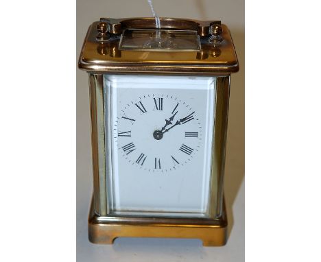 An early 20th century lacquered brass cased carriage clock, having enamelled dial with visible platform lever escapement and 