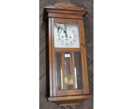 An oak cased striking wall clock