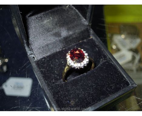 A 9 ct garnet and diamond ring hallmarked size 'R 1/2'.