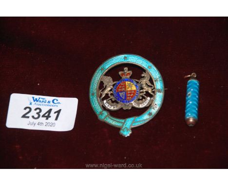 A 'sterling' enamelled cap badge and an engine turned turquoise enamelled pull action compact propelling pencil.