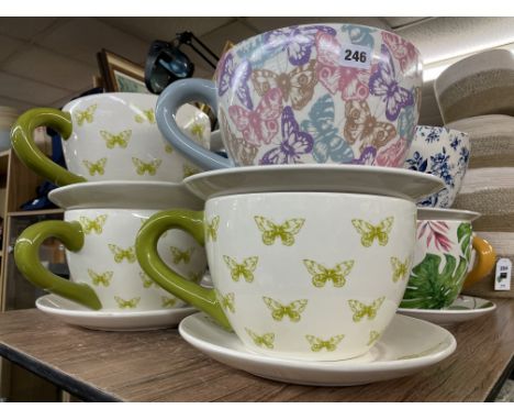 FOUR OVERSIZED CERAMIC BUTTERFLY PRINTED TEACUP AND SAUCER PLANTERS (THREE GREEN AND ONE MULTI COLOURED)