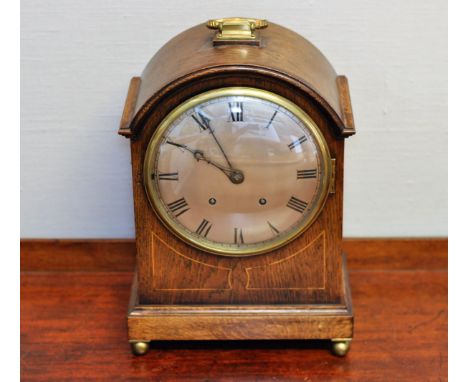AN OAK BRACKET MANTLE CLOCK, ARCHED TOP WITH GILT METAL BALL FEET, SILVERED FACE WITH BRASS CHAPTER RING, C.1895, STRIKING ON