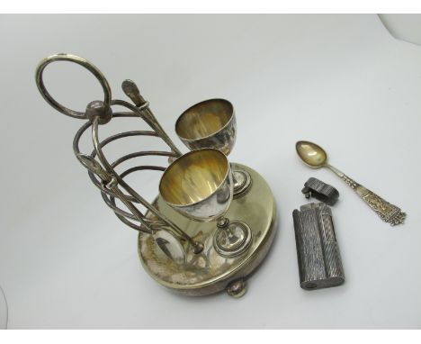 A Plated Egg Cup Stand with Integral Toast Rack, 1953 Royal Commemorative teaspoons, Dunhill lighter (D24864) allover texture
