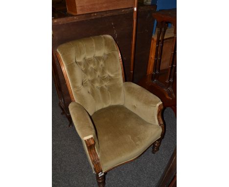 A Victorian walnut upholstered moss green velvet fireside chair, button back, turned supports