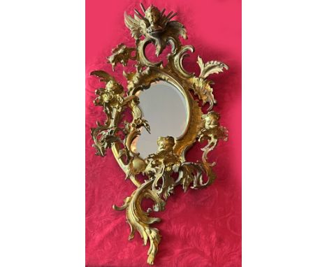 Wandapplik, Messingbronze, Rokoko Ornamentik, dreiflammig, mtit Putte als oberem Abschluss, Altersspuren, H 67, B 35 cm. Wall