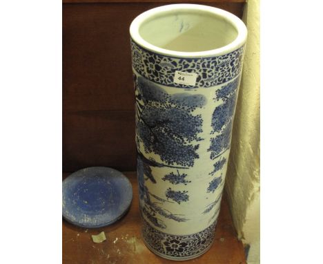 Oriental blue and white cylindrical porcelain stick stand with wooden cover.