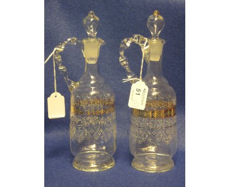 Pair of late Victorian clear glass, enamel decorated ewers with blown stoppers and loop handles. (2)