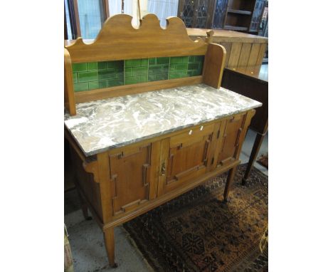 Edwardian satin walnut, marble top and tiled back washstand on ceramic castors.