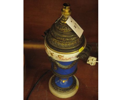 19th Century style gilt metal and porcelain mounted lamp base decorated with rams head mounts, floral swags and cherubs on a 