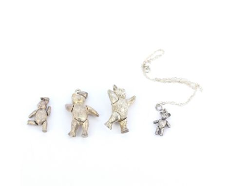 A group of silver teddy bear jewellery items including two pendants, a pendant and chain and a brooch.