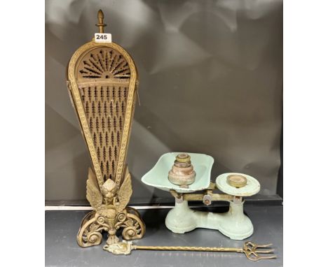 A brass fan fire screen, toasting fork and enamelled scale.