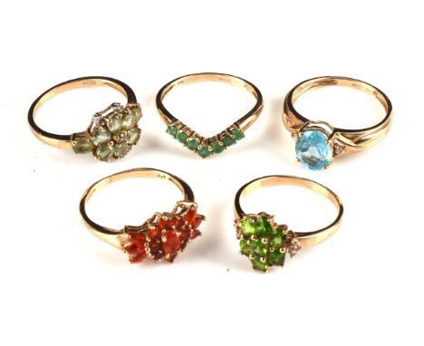 Five rings, including an oval cut blue Topaz with diamond set shoulders ring, size O1/2, a floral cluster ring set with oval 