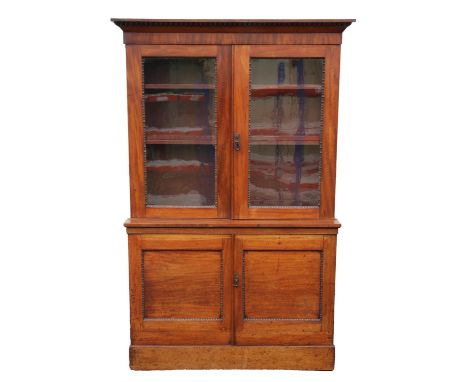 An early Victorian mahogany bookcase, with glazed upper section with reel turned mouldings, enclosing three shelves, above tw