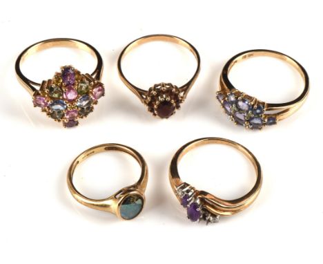Five gem set rings, including a three row oval cut tanzanite cluster ring, size O 1/2, a garnet cluster ring with tapered sho