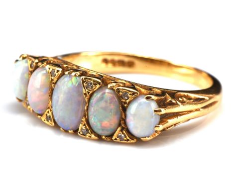 1960's five stone opal and diamond ring, carved half hoop design, with five oval cabochon cut opals, separated by single cut 