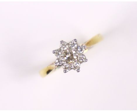 An 18ct. gold ring set cluster of small diamonds, the centre stone approx. 0.2 carat; size: N, 2.8gm.