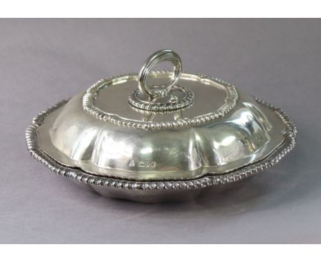 A LATE VICTORIAN SILVER ENTRÉE DISH of lobed circular form with gadrooned rims, the cover with detachable centre ring handle,