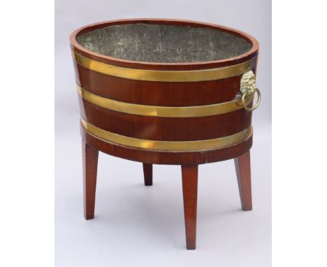 A regency mahogany &amp; brass-bound wine cooler, with lead-lined interior &amp; brass lion-mask ring side handles, on square