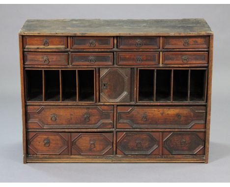 A 17th century oak chest fitted with an arrangement of twelve graduated drawers &amp; two sets of pigeon holes around a centr