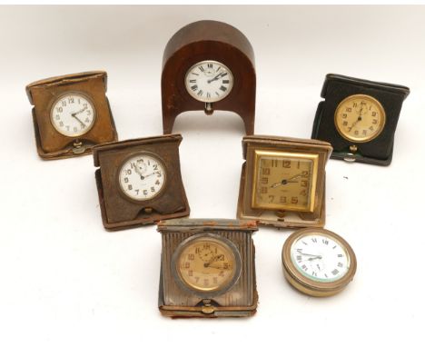 A collection of seven traveling 8 day bedside clocks, circa 1920s/30s, one mounted on clock case. (7)