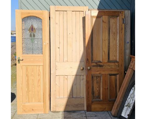 A selection of eight stripped pine internal doors, comprising three with leaded light panels, 197x58cm, and five panelled exa