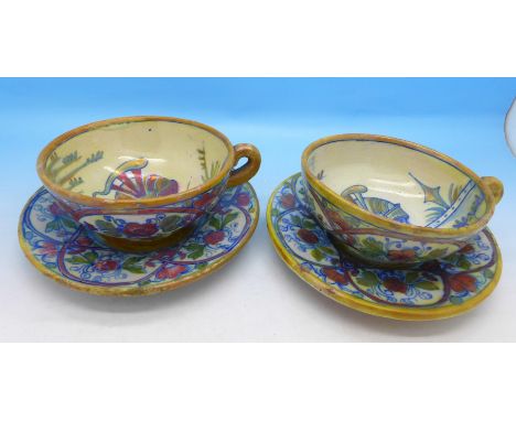 A pair of cups and saucers decorated with Grecian soldiers
