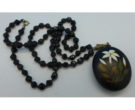 A Pietra Dura pendant on a black bead chain