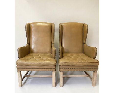 WING ARMCHAIRS, a pair, George III design, with studded light tan leather, each with button upholstered cushion, 62cm W. (2) 