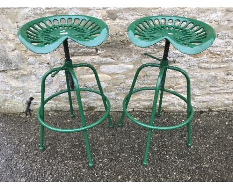 A pair of modern cast metal green painted adjustable tractor seat stools