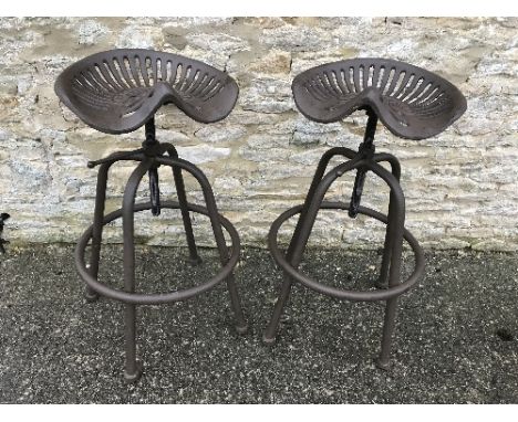 A pair of modern cast metal patinated adjustable tractor seat stools, each seat inscribed "WM Doyle &amp; Co. Limited"