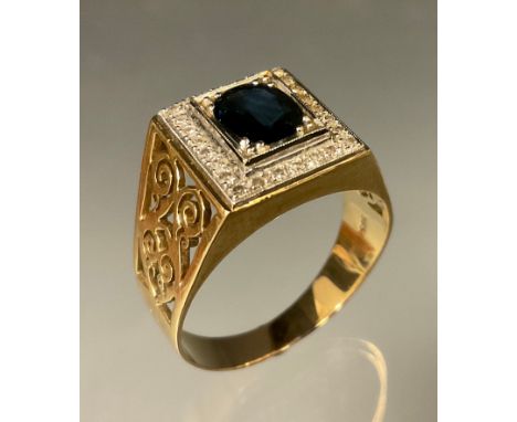 A sapphire and diamond gentle ring, central oval blue grey sapphire, surrounded by twenty six diamond accents, 15ct gold shan