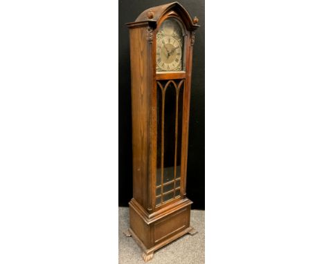 A Gothic Revival oak longcase clock, 30-day musical, chiming movement, brass dial, Roman numerals. The case having Ogival arc