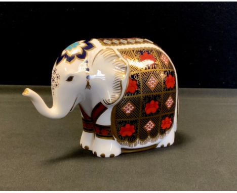 A Royal Crown Derby paperweight, Elephant, printed in the 1128 pattern, trunk raised, gold stopper, 10cm, printed marks 